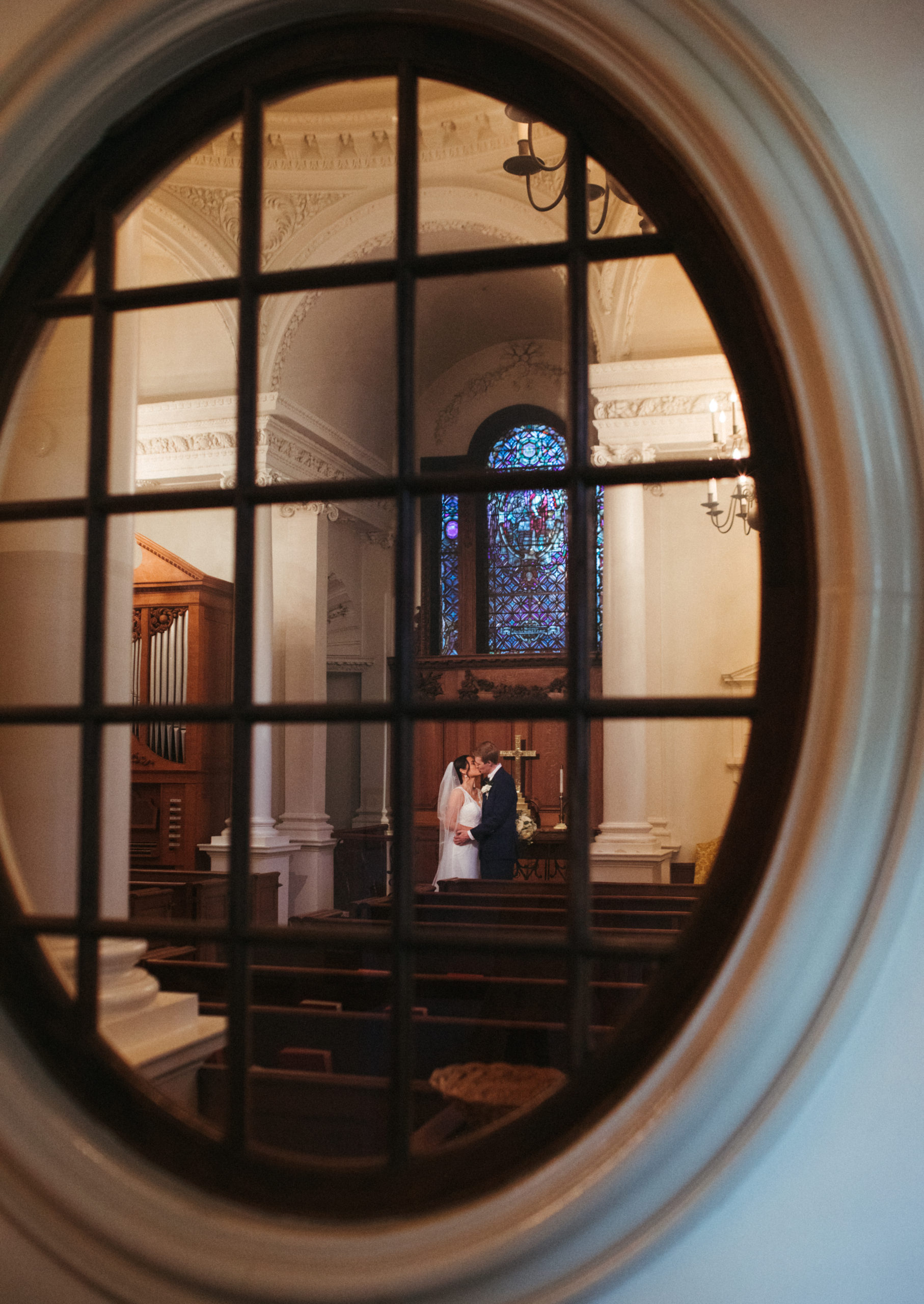 couple getting married through chapel window