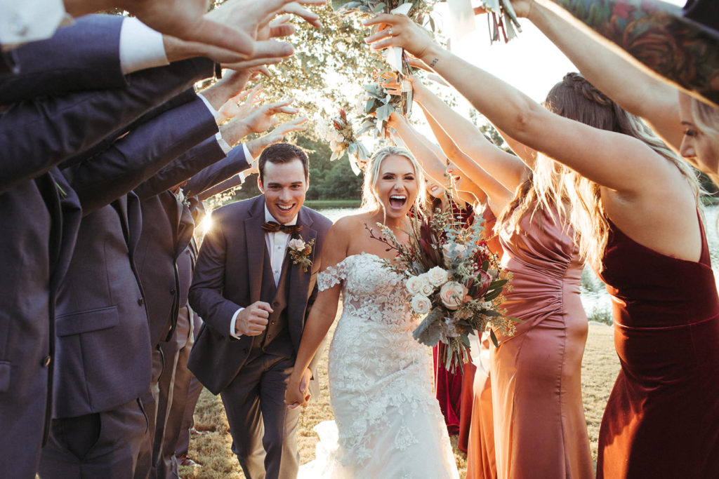bride and groom run through a tunnel created by their bridal party at the Taylor Estate in Rome Georgia