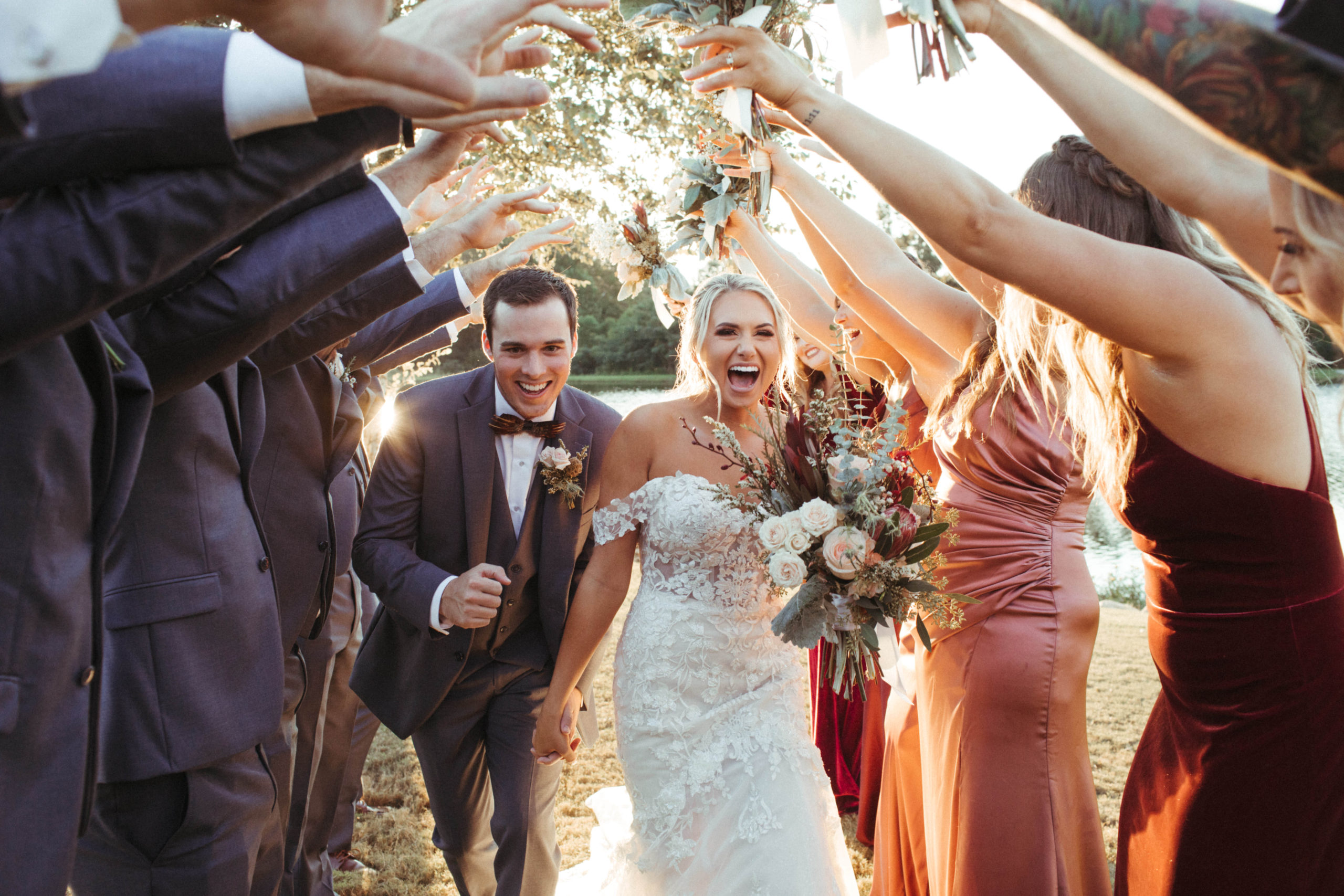 couple runs through tunnel made by their wedding party