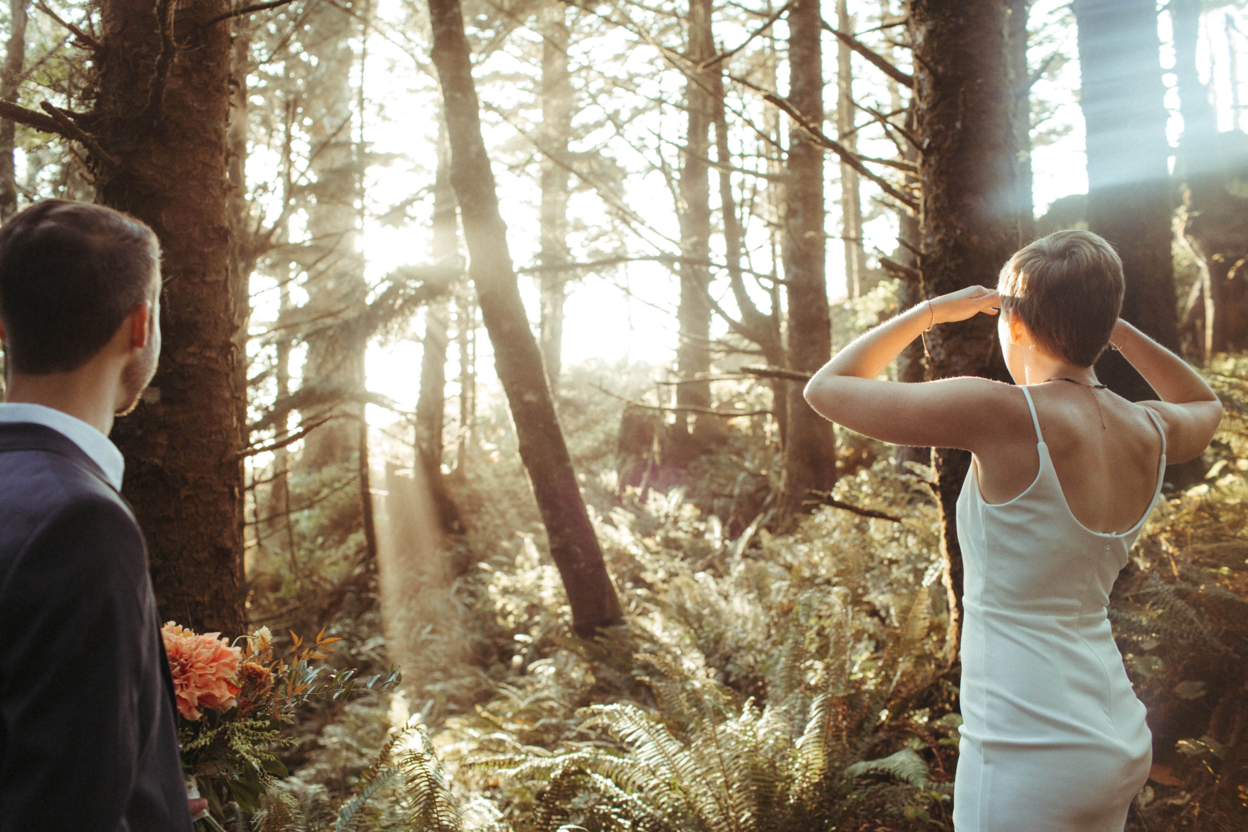 couple admiring the light beams through the pnw forest