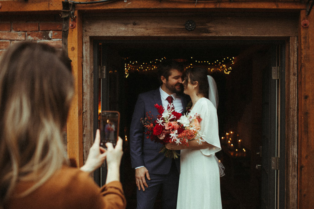 sister takes a picture of her sister and new brother in law