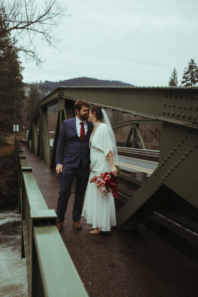 couple posing for wedding photos in white salmon washington at the husum falls bridge