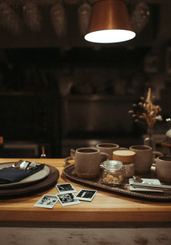 polaroids next to mugs on the counter at the ruby june inn