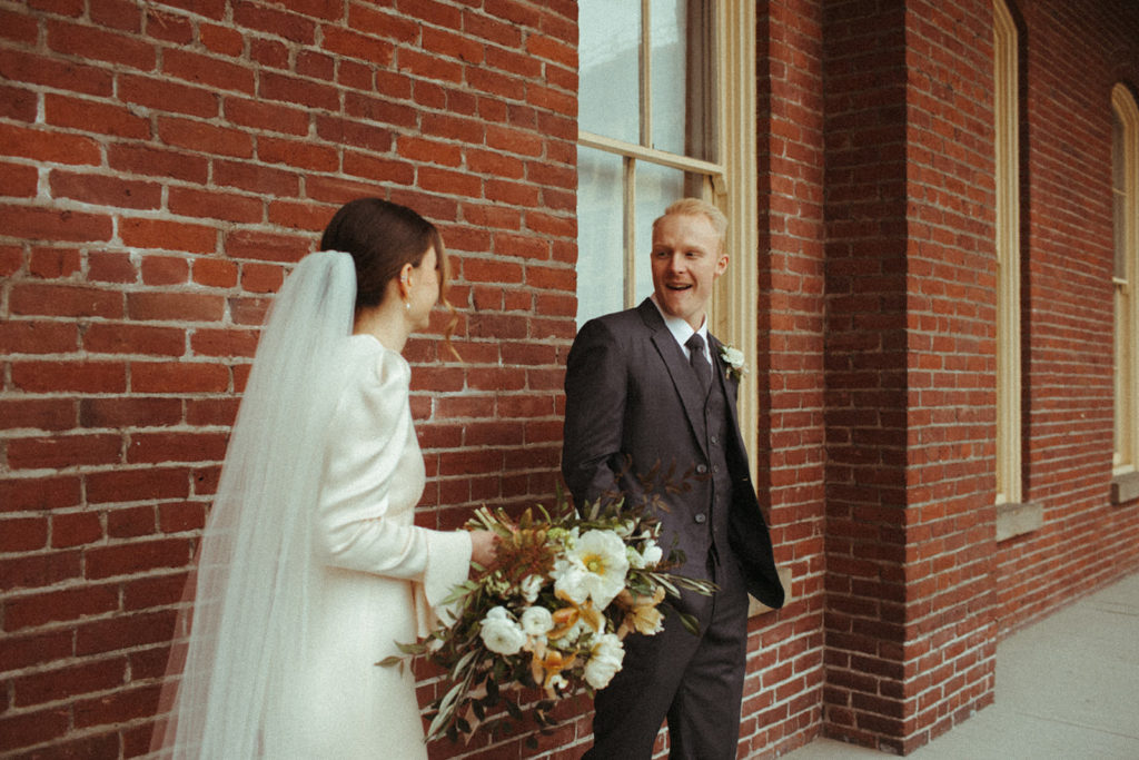 groom turns to see his bride during their first look outside of the Academy venue in Vancouver Washington