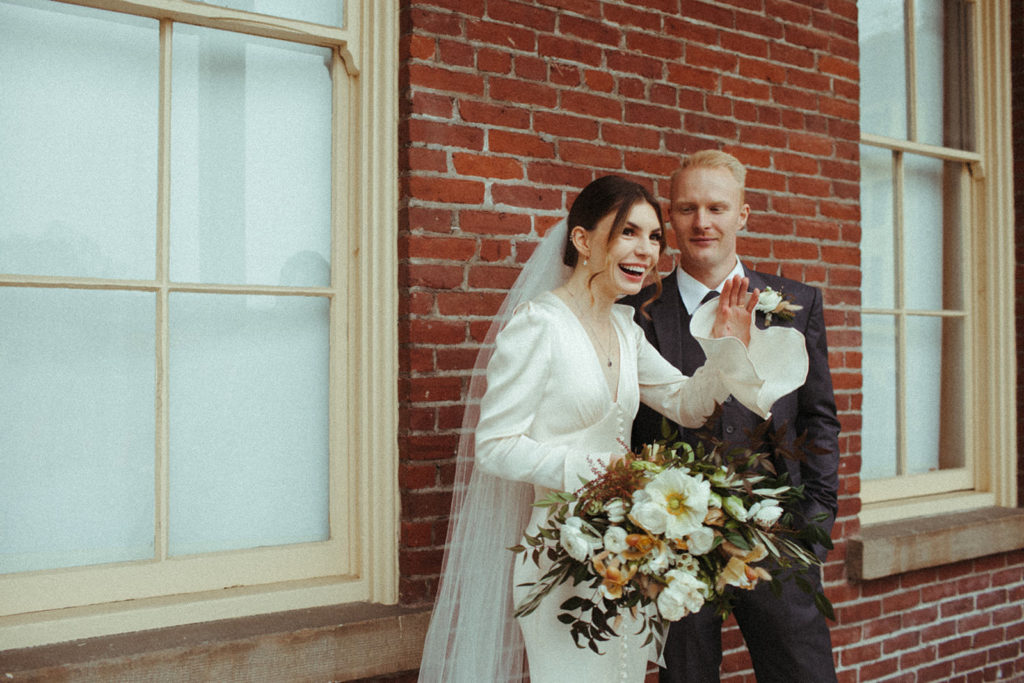 couple waves at arriving guests to their winter wedding in vancouver washington